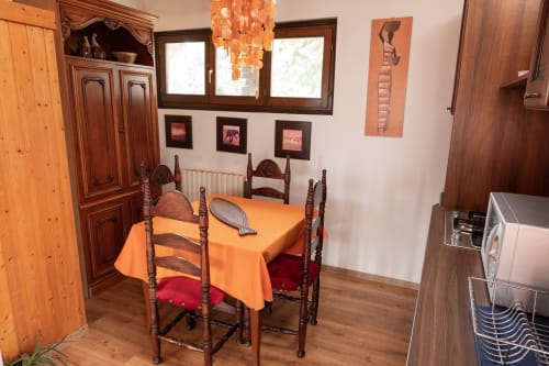 Sala da pranzo di Il Podere Prato con tavolo in legno, tovaglia arancione e sedie tradizionali a Predappio Alta
