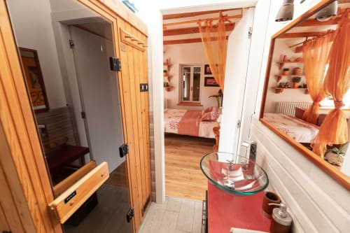 Bagno moderno a Il Podere Prato con lavabo rosso e mobili in legno che affaccia sulla camera da letto