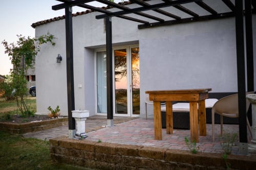 Patio moderno dell'agriturismo Il Podere Prato con tavolo in legno, pergolato e vista sul tramonto di Predappio Alta