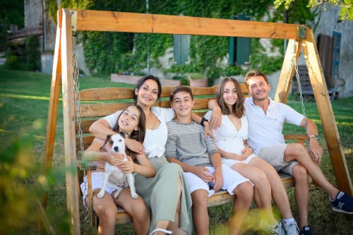Famiglia felice con cane su altalena in legno a Il Podere Prato, Predappio Alta, Italia