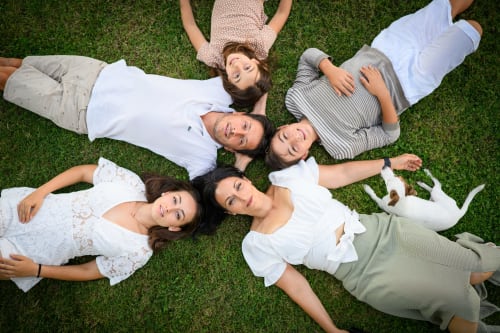 Gruppo di amici che si rilassano sull'erba dell'hotel Il Podere Prato a Predappio Alta, Italia