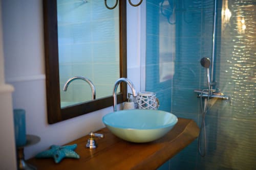 Bagno moderno a Il Podere Prato con lavabo d'appoggio, rubinetto cromato, specchio, parete in piastrelle blu e box doccia