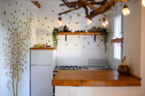 Angolo cottura moderno presso Il Podere Prato con decorazione murale in foglia d'oro, ripiani in legno, fornello a gas e illuminazione d'atmosfera a Predappio