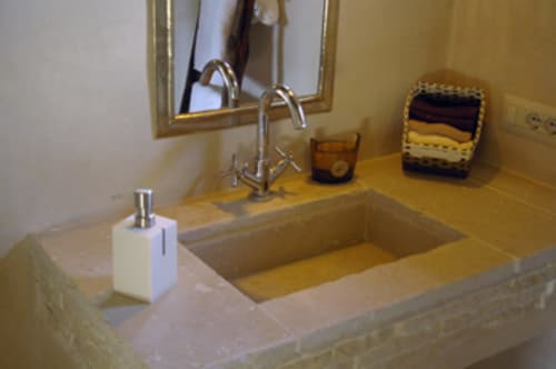 Bagno di Casale di Poggioferro con lavabo in marmo, rubinetto cromato, specchio e dispenser di sapone