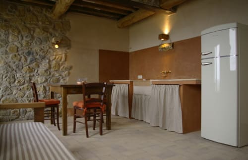 Cucina rustica dell'agriturismo Casale di Poggioferro con muri in pietra, travi di legno, elettrodomestici vintage