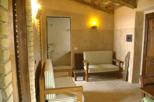 Rustico appartamento a Casale di Poggioferro con mobili in legno rigato, illuminazione calda e muri in mattoni a vista