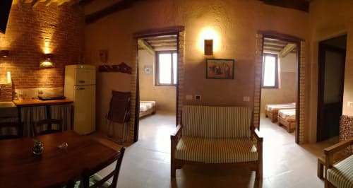Rustico appartamento al Casale di Poggioferro con mattoni a vista, illuminazione calda, angolo cottura e spazio aperto che si collega a