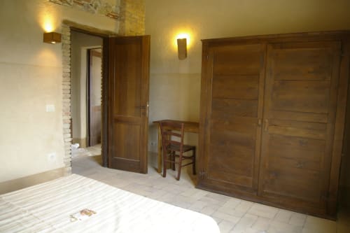 Camera da letto al Casale di Poggioferro con letto, armadio in legno e arredi rustici a Poggioferro, Italia