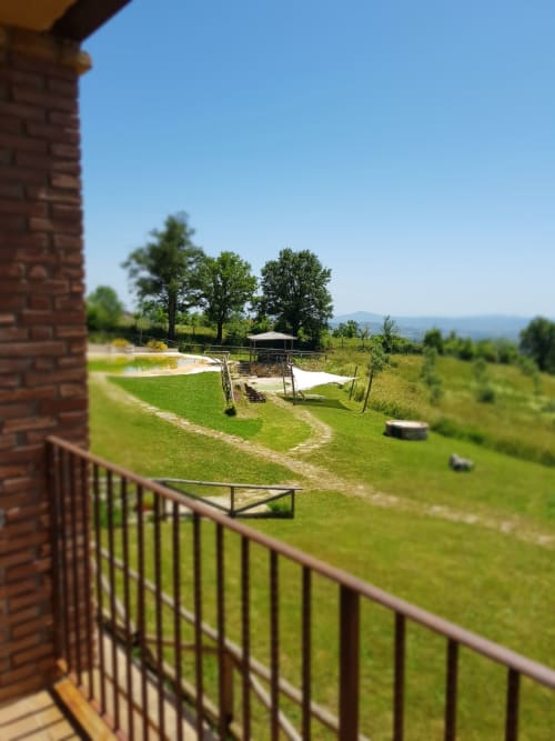 Balcone di Casale di Poggioferro con vista sulla verdeggiante campagna toscana e colline lontane