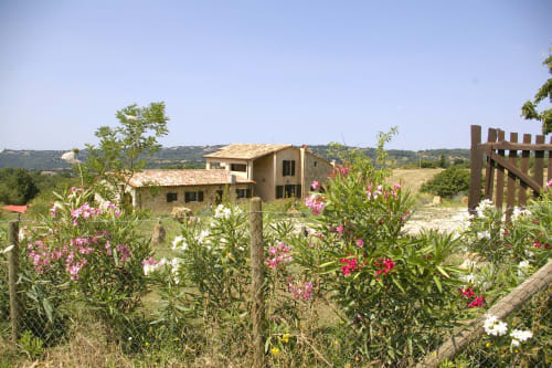 Casale di Poggioferro circondato da fiori in fiore, vedute della campagna toscana, architettura rustica di villa italiana