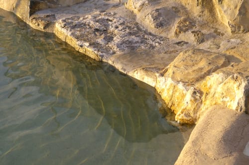 Vasca termale con acque minerali dorate a Casale di Poggioferro, simbolo della Toscana