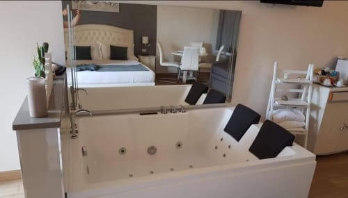 Lussuoso bagno spa con vasca idromassaggio presso B&B Emozioni Relax a Mantova, vista della camera da letto nello specchio