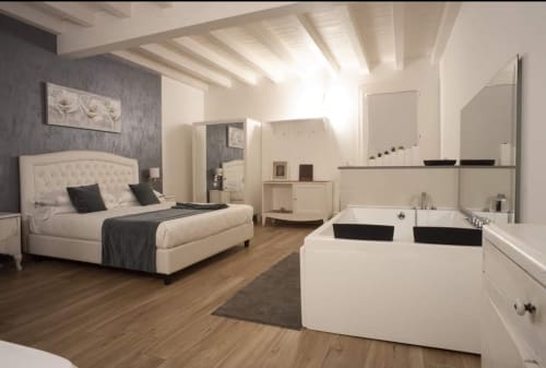Camera da letto moderna con bagno ensuite presso il B&B Emozioni Relax di Mantova, con letto color crema e arredi contemporanei