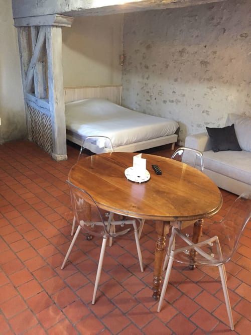 Studio à l'Hôtel De La Bonnheur à Bracieux avec lit à baldaquin, table à manger et carrelage en terre cuite