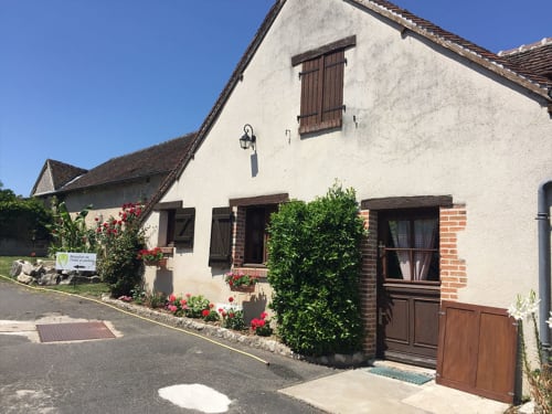 Charmant cottage en pierre blanche avec volets rouges et fleurs à l'Hôtel De La Bonnheure à Bracieux, France