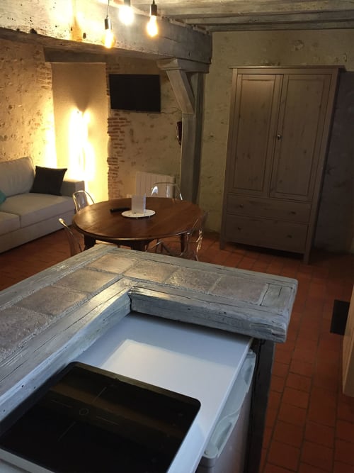 Studio rustique à l'Hôtel De La Bonnheur à Bracieux avec kitchenette, table à manger et murs en briques apparentes