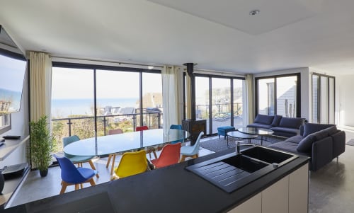 Vue panoramique de l'intérieur de la Villa Gabrielle, avec un espace de vie moderne et lumineux donnant sur la mer.