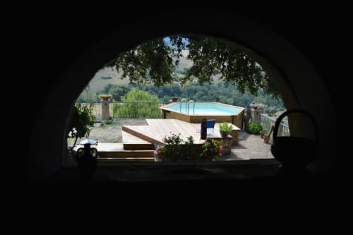 Blick auf den Pool und die Terrasse von Agri-Bio Santa Palmira in Pomarance durch einen Bogeneingang
