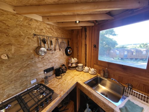 Cozy kitchenette in La Yourte de Bouddha cottage at Les Refuges Du Chalet, Jalhay, with wooden finishes, gas cooktop, and