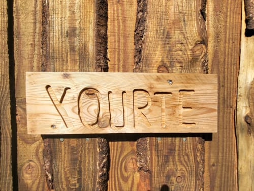 Wooden 'YOURTE' sign carved into light wood plank at Les Refuges Du Chalet cottage in Jalhay, Belgium
