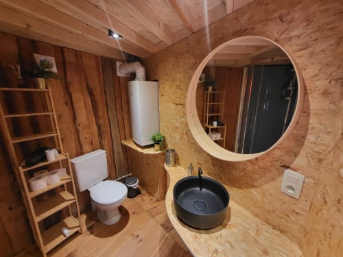 Modern bathroom in La Yourte de Bouddha cottage at Les Refuges Du Chalet, Jalhay, featuring cork walls, black vessel sink,
