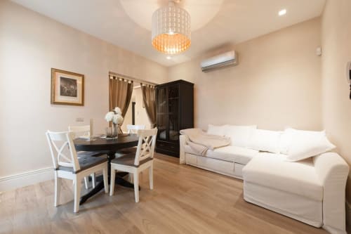Appartamento spazioso a Fortezza da Basso a Firenze con divano color crema, tavolo da pranzo e pavimenti in legno