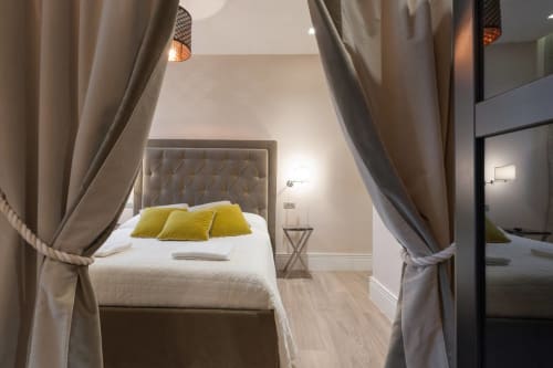 Camera da letto lussuosa alla Fortezza da Basso a Firenze con letto a baldacchino, cuscini gialli e vista sulla città