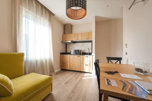 Appartamento moderno a Fortezza Da Basso a Firenze con sedia gialla, cucina in legno e tavolo da pranzo