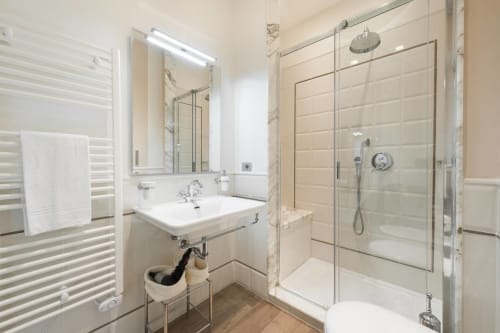 Bagno moderno nell'appartamento di Firenze con lavabo, specchio, box doccia in vetro e scaldasalviette