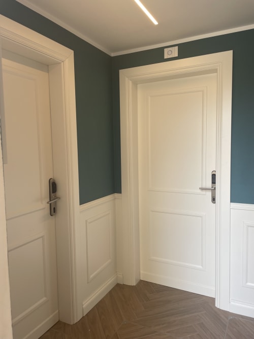 Moderno corridoio con porte color panna e pareti verde teal nella Jack Room del Covo del Pirata, hotel a Venezia