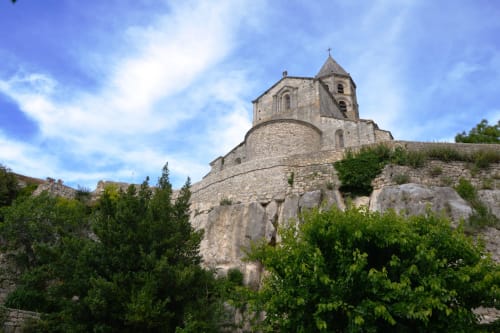 Historic stone church perched on rocky hillside in Grignan, France, near Le Pavillon M accommodation
