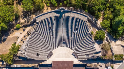 Aerial view of ancient Roman amphitheater nestled in greenery near Grignan, France