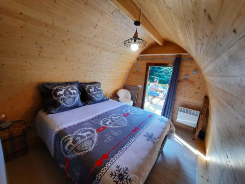 Cozy wooden glamping refuge bedroom at Belloréade with queen bed, garden view, and heating at Belloc property