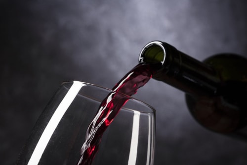 Red wine pouring from bottle into glass at Le Pavillon M, luxury guesthouse in Grignan