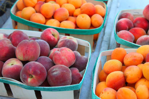 Fresh apples and oranges in market crates, local produce near Le Pavillon M, Grignan