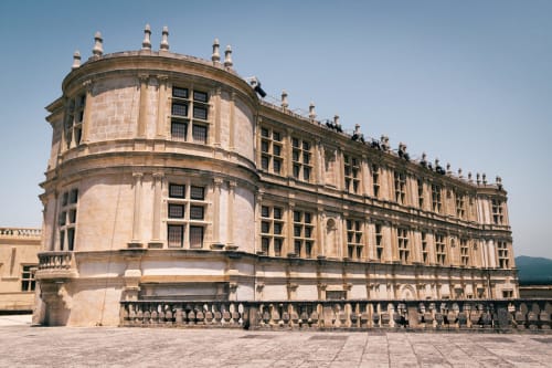 Historic stone mansion Le Pavillon M in Grignan with circular tower and manicured courtyard