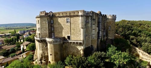 Medieval stone castle tower in Grignan, France with battlements and countryside views, near Le Pavillon M guesthouse