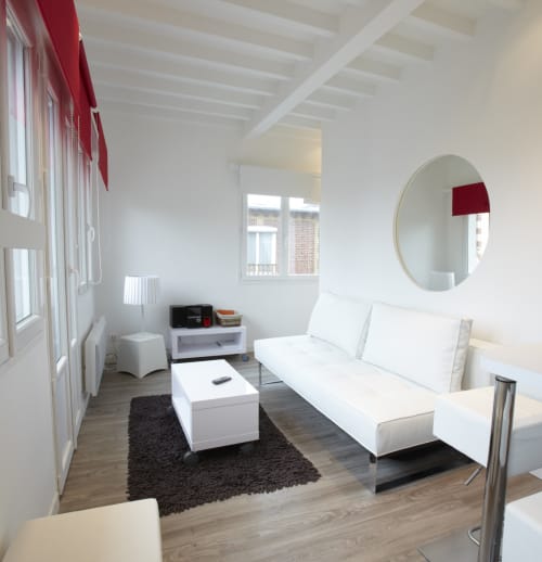 Coin salon spacieux et confortable du Gîte Gabrielle, avec de grandes fenêtres apportant une lumière naturelle abondante.