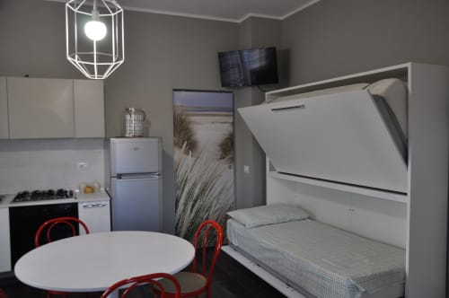 Equipped kitchen at Casa Marzi in Pesaro with table and bunk bed in the living room - near B&B Albornoz in Urbino, Marche.