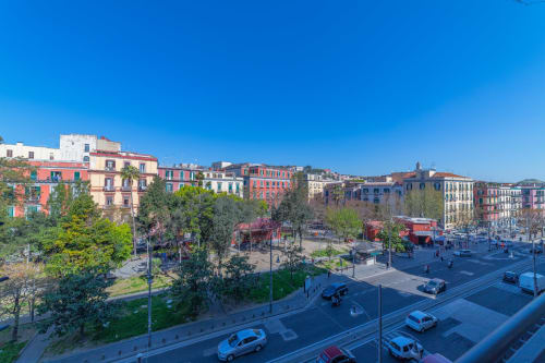 Colorido paisaje urbano de Nápoles con piazza, edificios históricos y cielo azul desde el balcón del Museo19