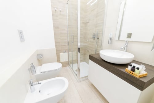 Baño moderno en Museo19 Nápoles con doble lavabo, ducha de lluvia y vanidad de madera