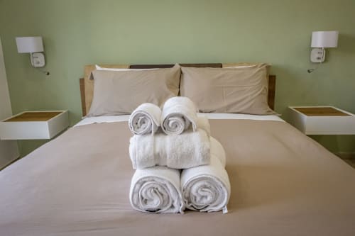 Camera Superiore con letto a Museo19 Napoli, asciugamani bianchi arrotolati e pareti verde salvia, vista sulla città