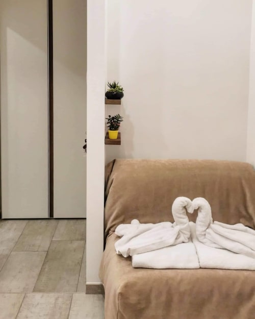 Habitación Estándar en Museo19 BnB en Nápoles con cama, toallas blancas, plantas en macetas y decoración minimalista moderna