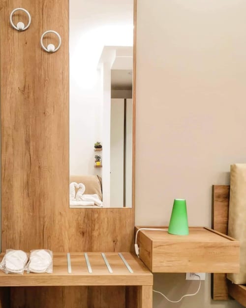 Baño moderno de madera en Museo19 Nápoles con espejo, toallas, amenities y detalles decorativos verdes