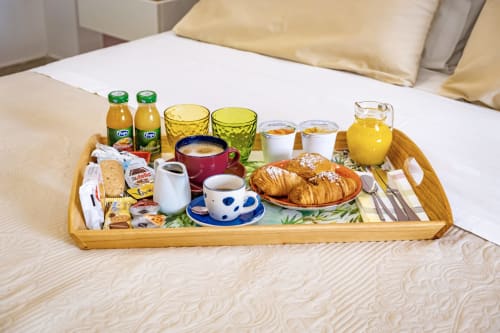 Breakfast tray with croissants, juice, coffee, and pastries in a Deluxe Room at Museo19 bed and breakfast in Naples