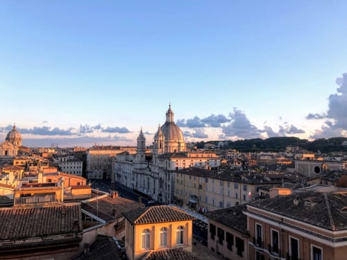 Skyline di Roma al tramonto con chiesa a cupola e edifici color terracotta vicino ad AD Trastevere Guest House