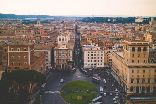 Aerial view of Rome showing historic buildings, streets, and cityscape with green plaza in center