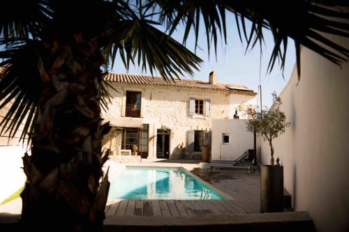 Cour du Mas Lafleur avec piscine, villa en pierre et palmiers à Châteaurenard