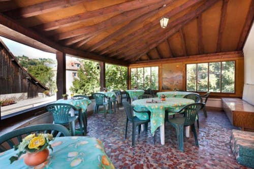 Salle à manger couverte de la Résidence Soansa du Gérardmer avec nappes turquoise, poutres en bois et vue sur les montagnes