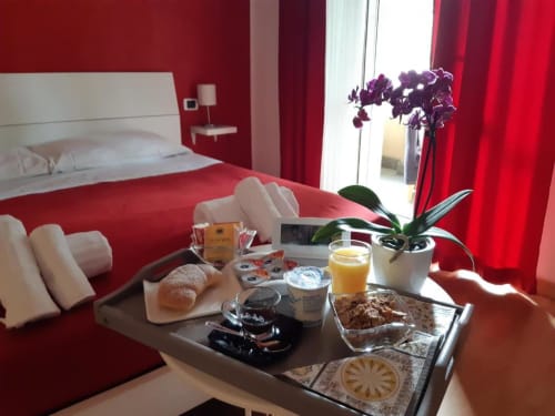 Camera Rossa presso AD Trastevere Guest House a Roma con vassoio colazione, orchidee e vista della città